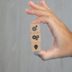 business concept grey table side view hand holding wooden cubes with icons